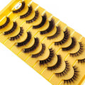 Set of false eyelashes on a yellow tray with a white background