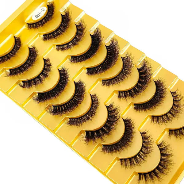 Set of false eyelashes on a yellow tray with a white background