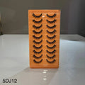 Set of false eyelashes in an orange holder on a white surface