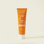 Orange tube of Blesso Vitamin C brightening cleanser on a beige background