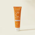 Orange tube of Blesso brightening face scrub on a beige background