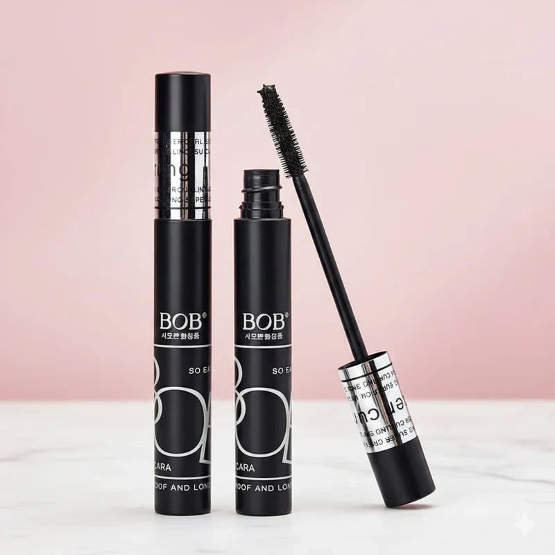 BOB Super Curl Mascara Thick Intense Waterproof with open cap on a white surface against a pink background