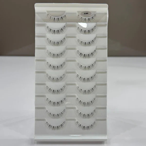 Set of false eyelashes in a white tray on a gray background