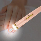 Pink and gold pen with a light on a white surface