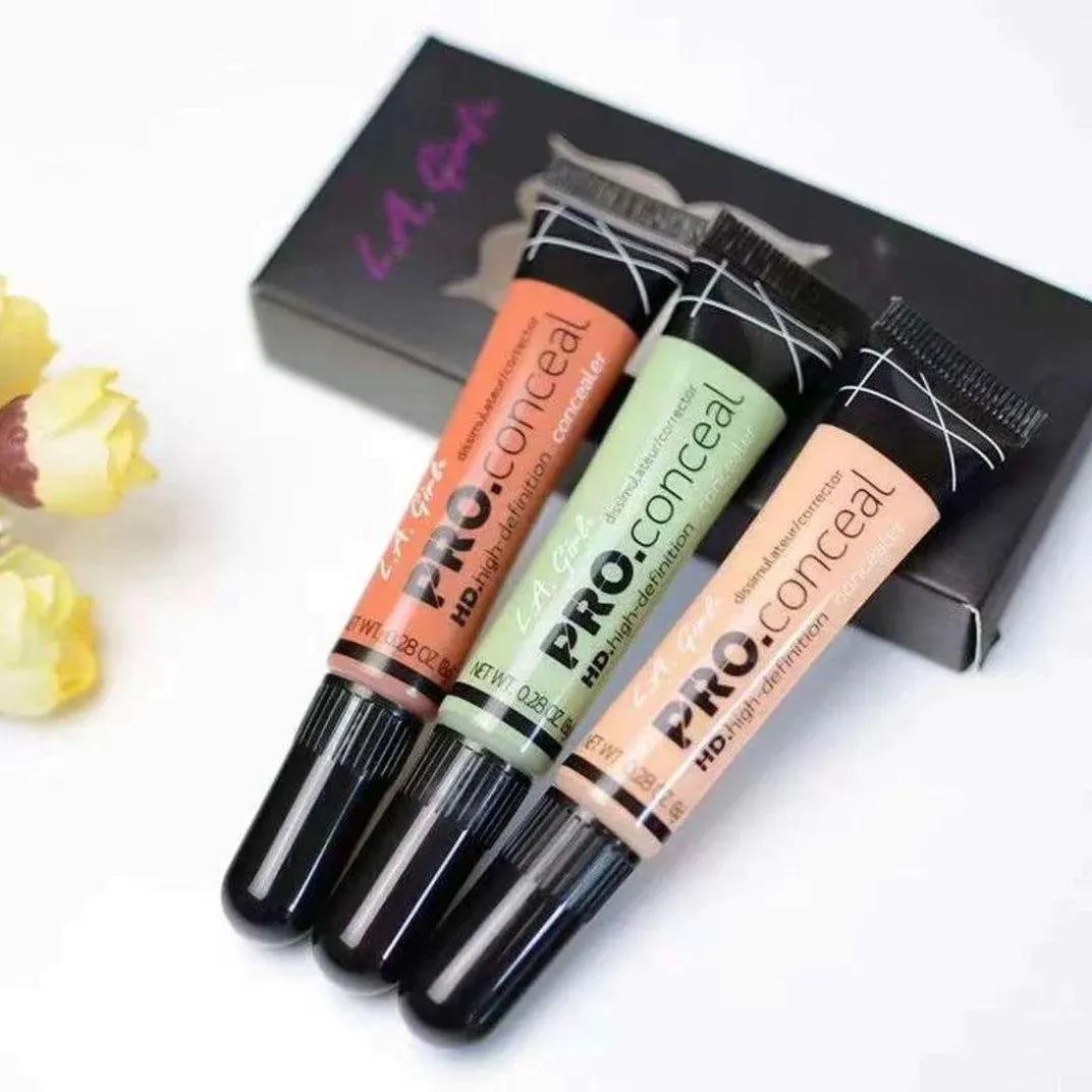 Three L.A. Girl Pro Conceal makeup products with a box in the background.
